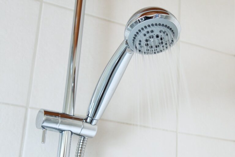 silver shower head in white tiled shower