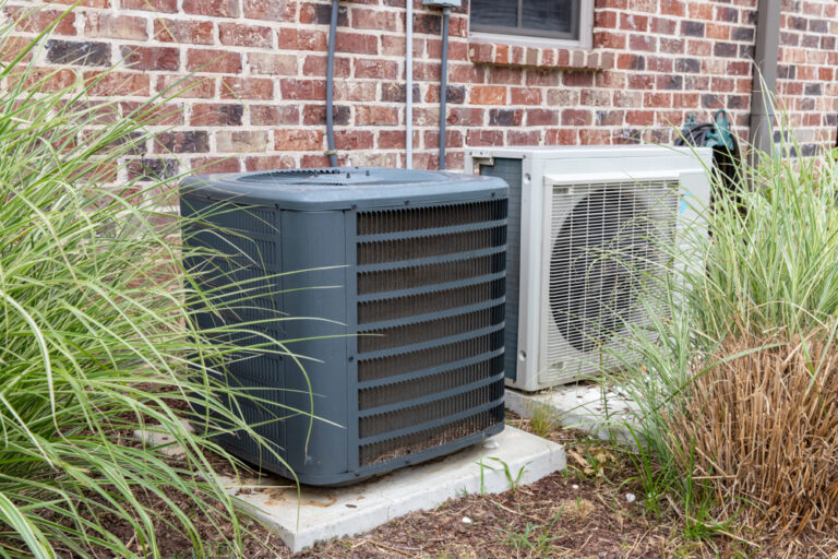 air-conditioning-unit-sitting-in-some-bushes