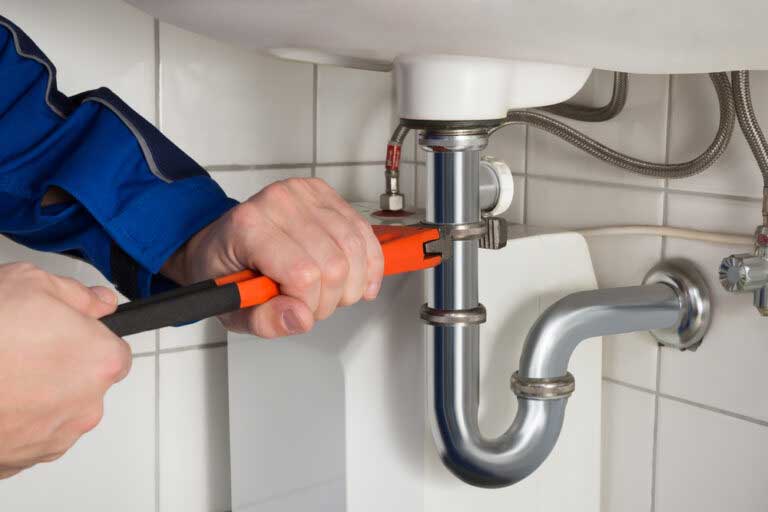 Plumber fixing sink with wrench