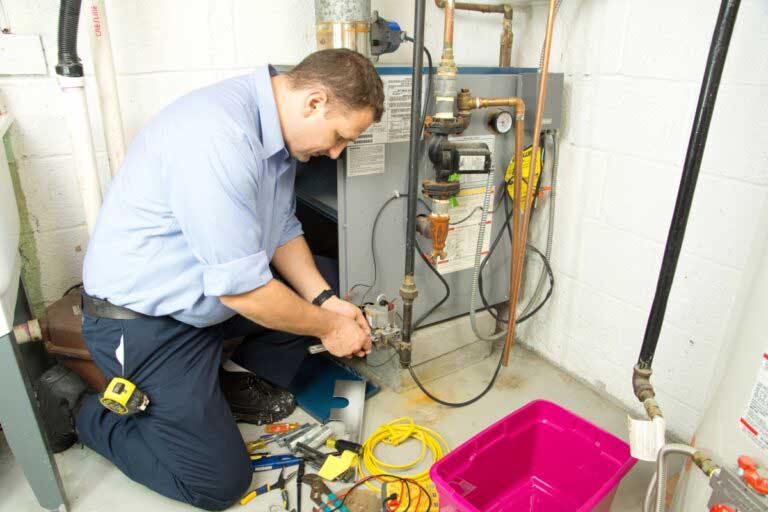 repair person fixing heating system in edmonton home